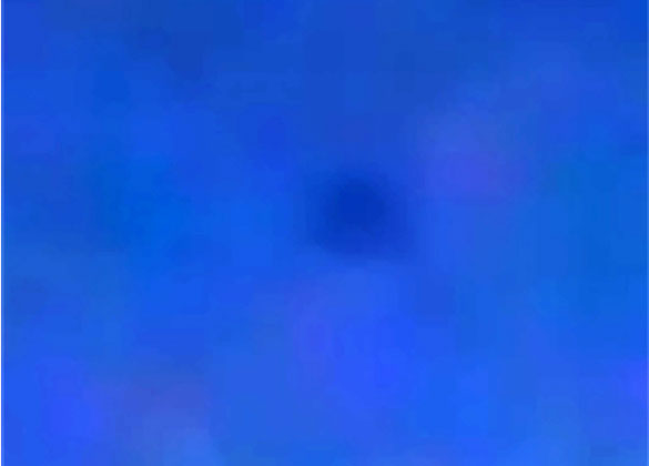Cropped and enlarged still frame from the witness video shows a very fuzzy view of the triangle-shaped object the witness said was visible hovering in the sky to the naked eye. (Credit: MUFON)