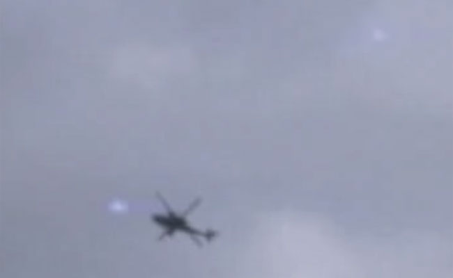 A still image taken from the video, showing a helicopter and multiple balls of light. (Credit: George Taylor/YouTube)